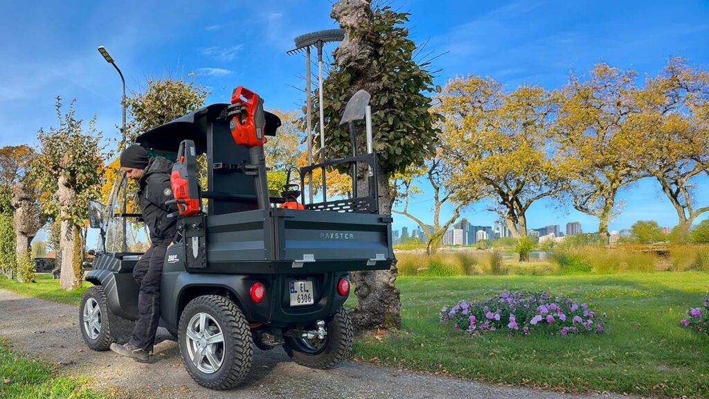 A Paxster Utility efficiently navigating through a park, showcasing its versatility and eco-friendly design.